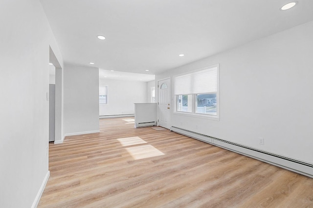unfurnished living room featuring recessed lighting, a baseboard heating unit, and light wood finished floors