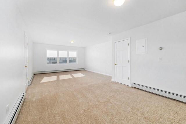 spare room with baseboards, a baseboard radiator, a baseboard heating unit, and light carpet