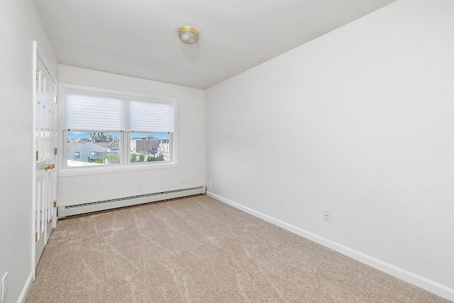 carpeted empty room featuring baseboards and a baseboard radiator