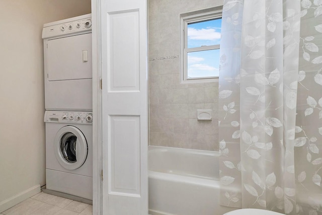 full bathroom with tile patterned floors, baseboards, stacked washer and clothes dryer, and shower / tub combo with curtain