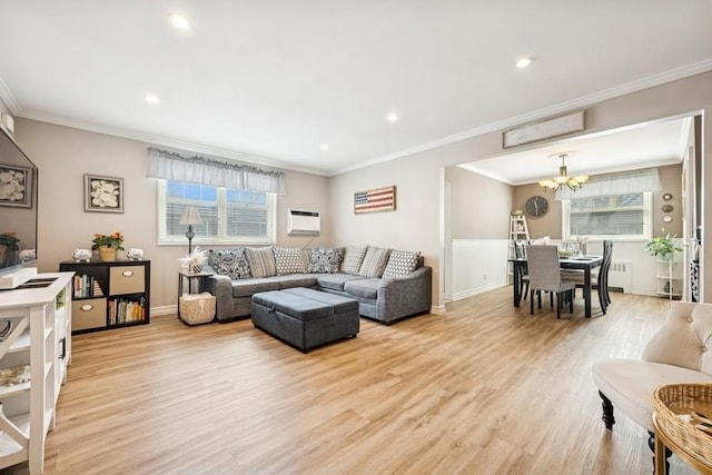 living area with a chandelier, plenty of natural light, ornamental molding, and light wood finished floors