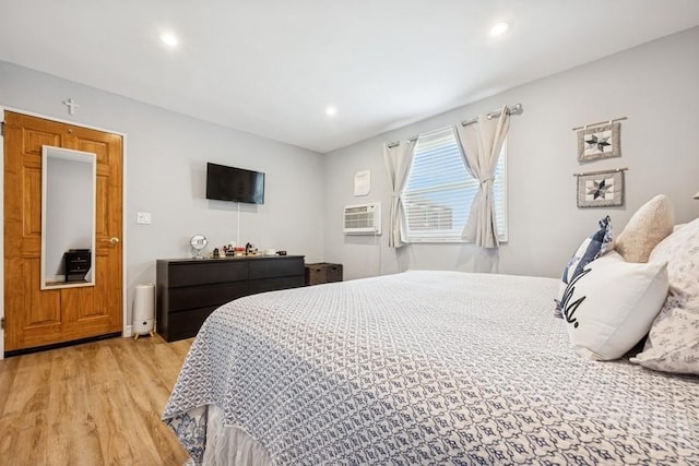 bedroom featuring recessed lighting, an AC wall unit, and light wood-type flooring