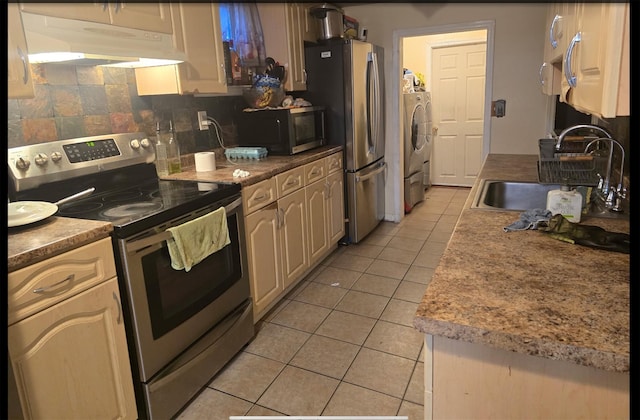 kitchen featuring light tile patterned floors, a sink, stainless steel appliances, under cabinet range hood, and backsplash