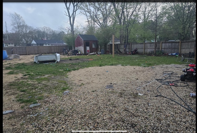 view of yard featuring an outbuilding, a storage unit, and a fenced backyard