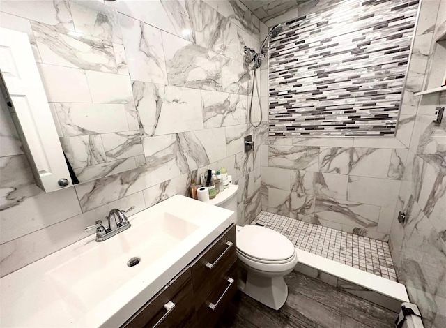 30 Delaware Ave, Long Beach, NY 11561 - bathroom featuring toilet, tile walls, tiled shower, and vanity