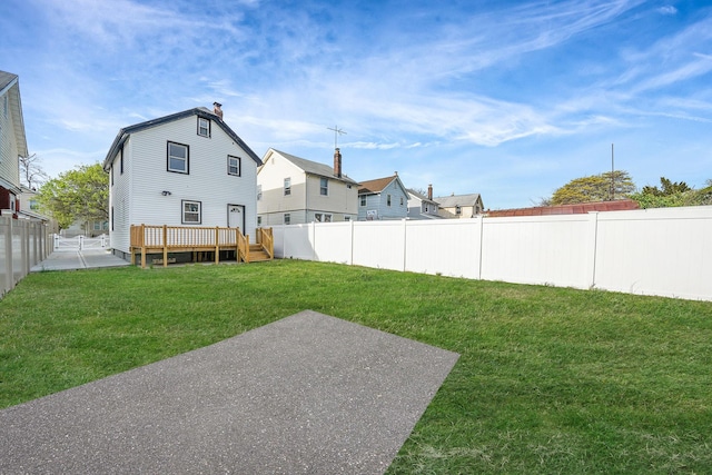 view of yard with a patio, a wooden deck, and a fenced backyard