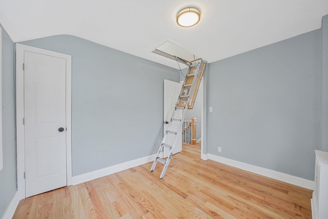 additional living space featuring baseboards, wood finished floors, and lofted ceiling