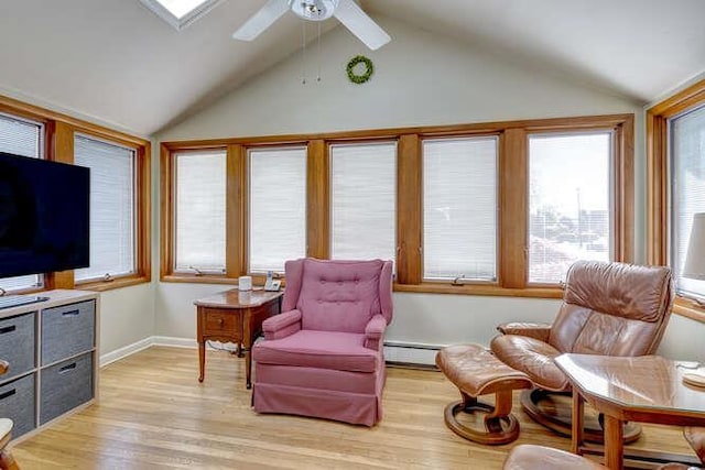 sitting room featuring a ceiling fan, baseboard heating, vaulted ceiling, and light wood finished floors