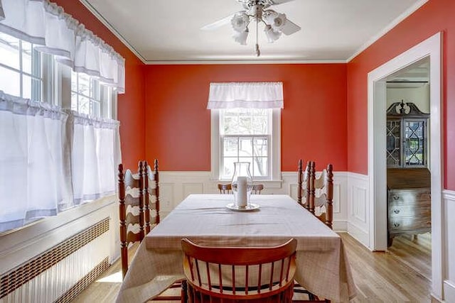 dining room featuring ornamental molding, wood finished floors, and a wealth of natural light