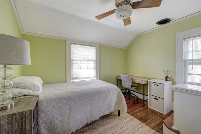 bedroom featuring ceiling fan, ornamental molding, vaulted ceiling, and wood finished floors