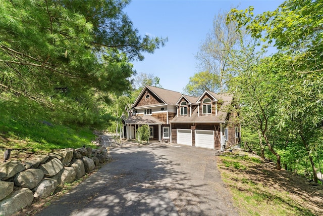 craftsman-style house with an attached garage and aphalt driveway