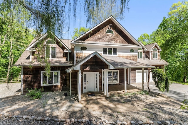 view of front of property featuring fence, a shingled roof, an attached garage, a porch, and concrete driveway