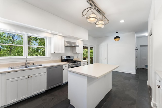 kitchen with stainless steel range with gas stovetop, a wealth of natural light, a sink, and wall chimney range hood