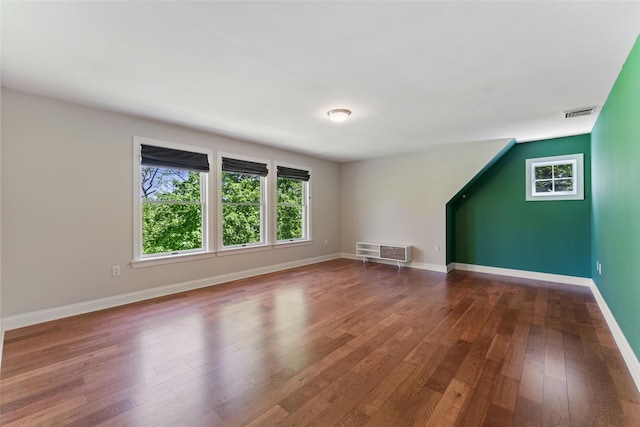 bonus room with dark wood-style flooring, baseboards, and visible vents