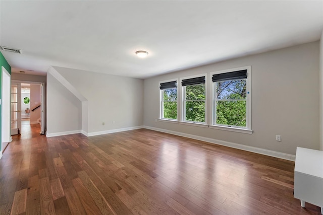 interior space featuring visible vents, baseboards, and dark wood-style floors