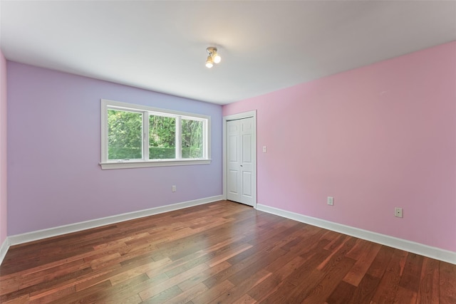 unfurnished room with baseboards and wood finished floors
