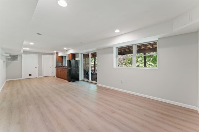 unfurnished living room with recessed lighting, baseboards, and light wood-type flooring