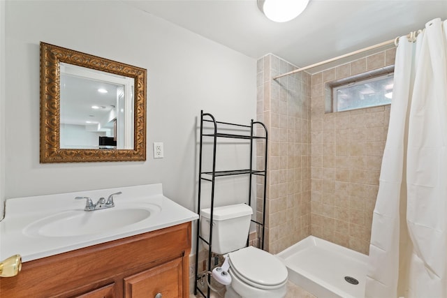 bathroom with vanity, toilet, and tiled shower