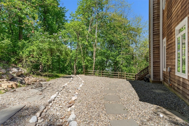 view of yard with a patio, fence, and stairs