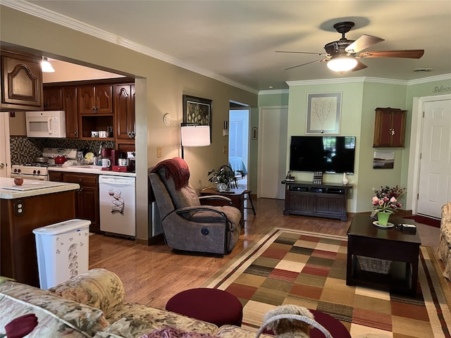living room featuring visible vents, ornamental molding, ceiling fan, and wood finished floors