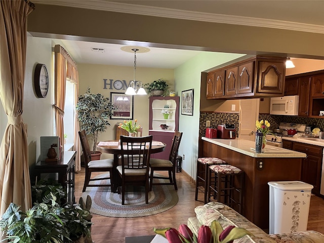dining room featuring dark wood-type flooring, baseboards, crown molding, and visible vents