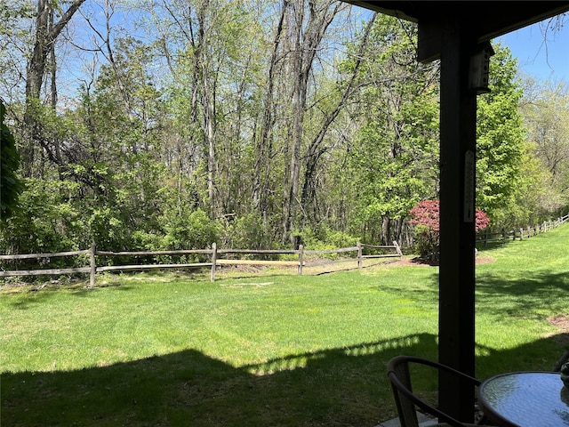 view of yard with a view of trees and fence