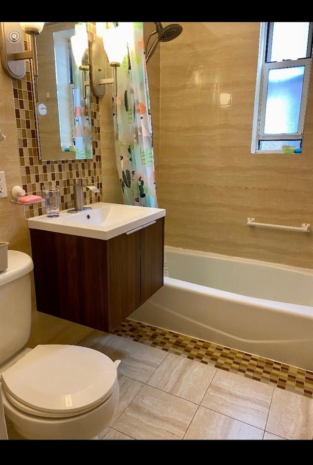 full bath featuring tile walls, tile patterned flooring, shower / bath combo, vanity, and toilet