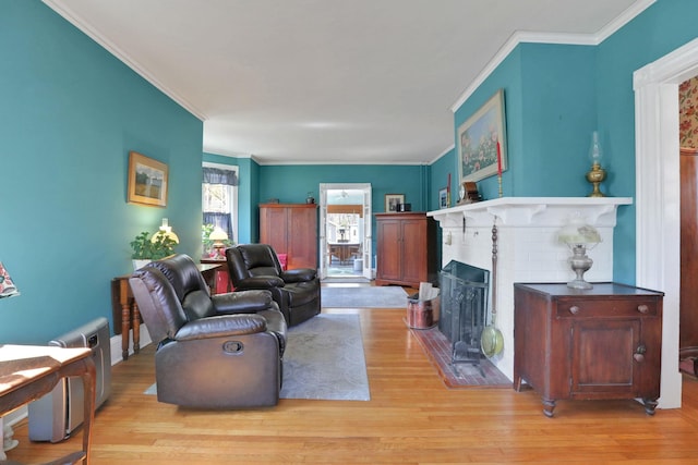 living room with ornamental molding, a brick fireplace, and wood finished floors
