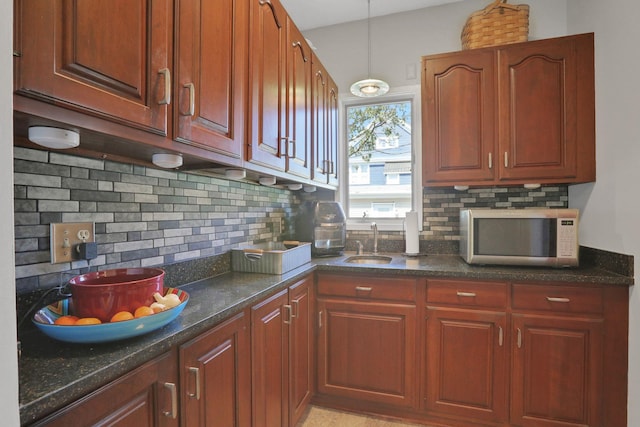 kitchen featuring decorative backsplash, a sink, and dark stone countertops