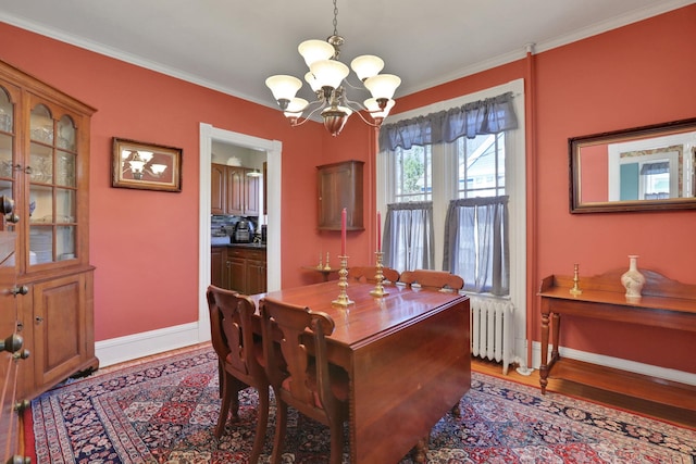 dining room with ornamental molding, baseboards, radiator heating unit, light wood-style flooring, and a notable chandelier