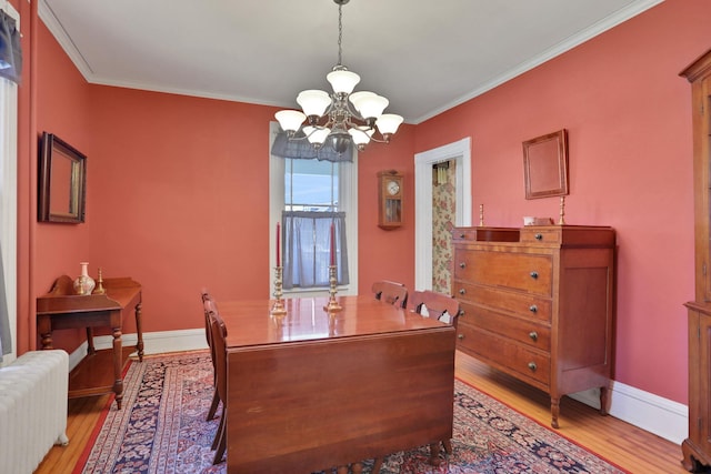 office featuring crown molding, light wood-type flooring, baseboards, a notable chandelier, and radiator heating unit