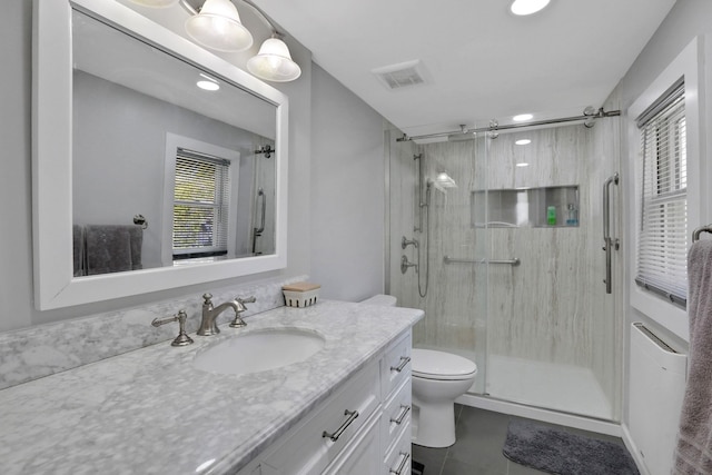 full bathroom featuring vanity, toilet, tile patterned floors, visible vents, and a stall shower