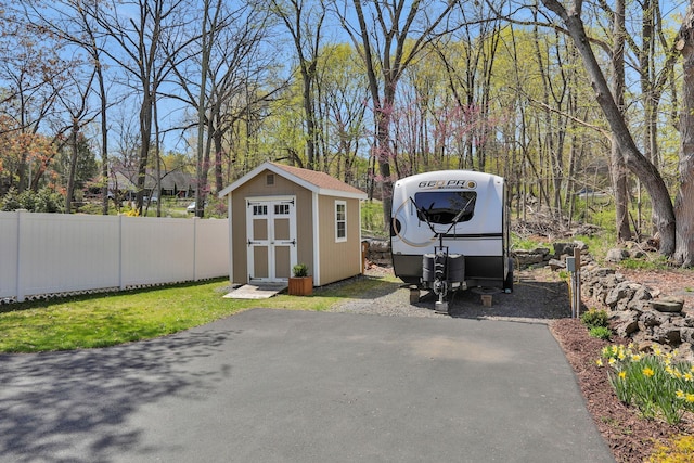 exterior space with fence, a storage unit, and an outdoor structure