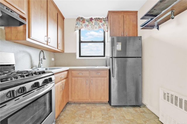 kitchen with stone finish floor, light countertops, a sink, exhaust hood, and stainless steel appliances