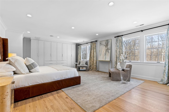 bedroom with crown molding, recessed lighting, visible vents, and wood finished floors