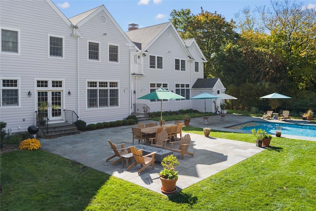 rear view of house with a yard, french doors, a patio, and an outdoor pool