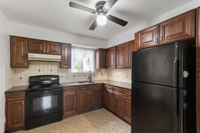 kitchen with black appliances, under cabinet range hood, a sink, dark countertops, and backsplash