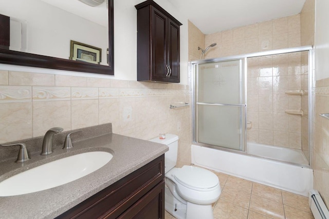 full bathroom with a baseboard radiator, enclosed tub / shower combo, tile walls, toilet, and vanity