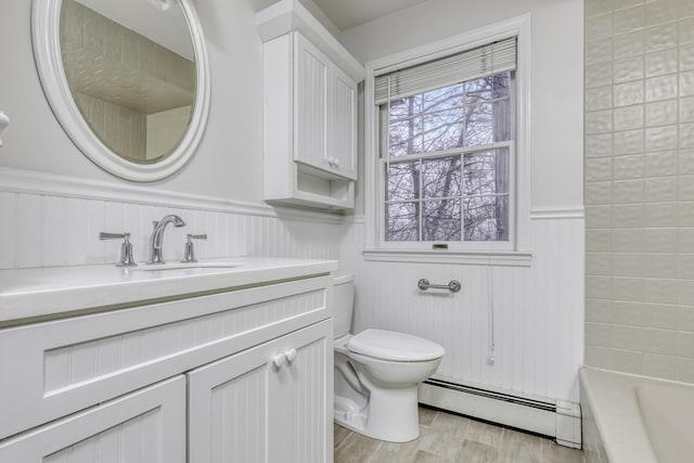 121 Thiells Rd, Stony Point, NY 10980 - full bathroom featuring wainscoting, wood finished floors, vanity, a baseboard radiator, and toilet