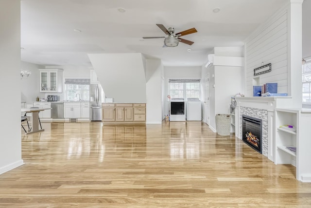 121 Thiells Rd, Stony Point, NY 10980 - living area featuring washer / dryer, baseboards, a tile fireplace, light wood finished floors, and ceiling fan with notable chandelier
