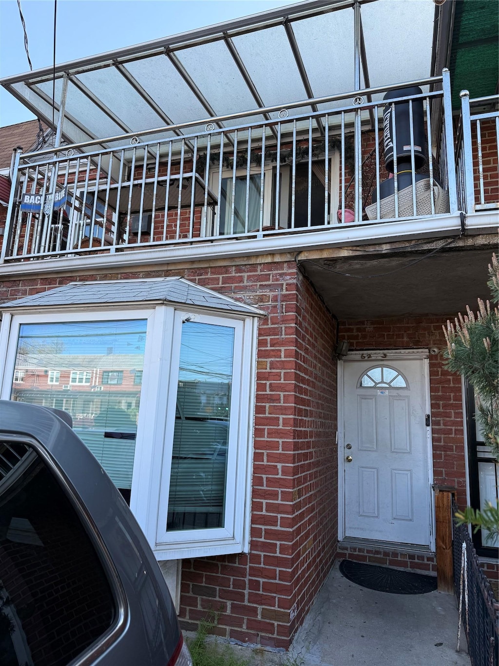 exterior space featuring brick siding and a balcony