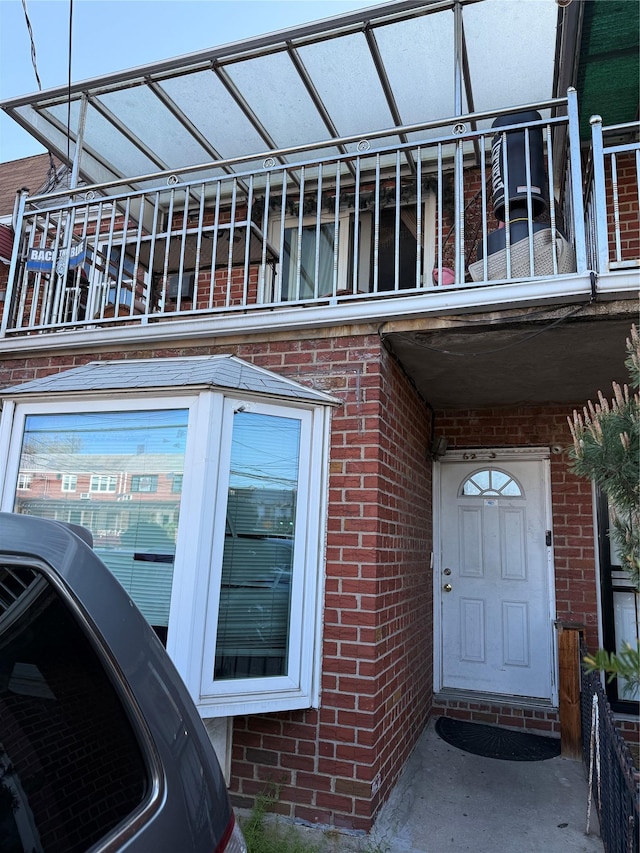 exterior space featuring brick siding and a balcony