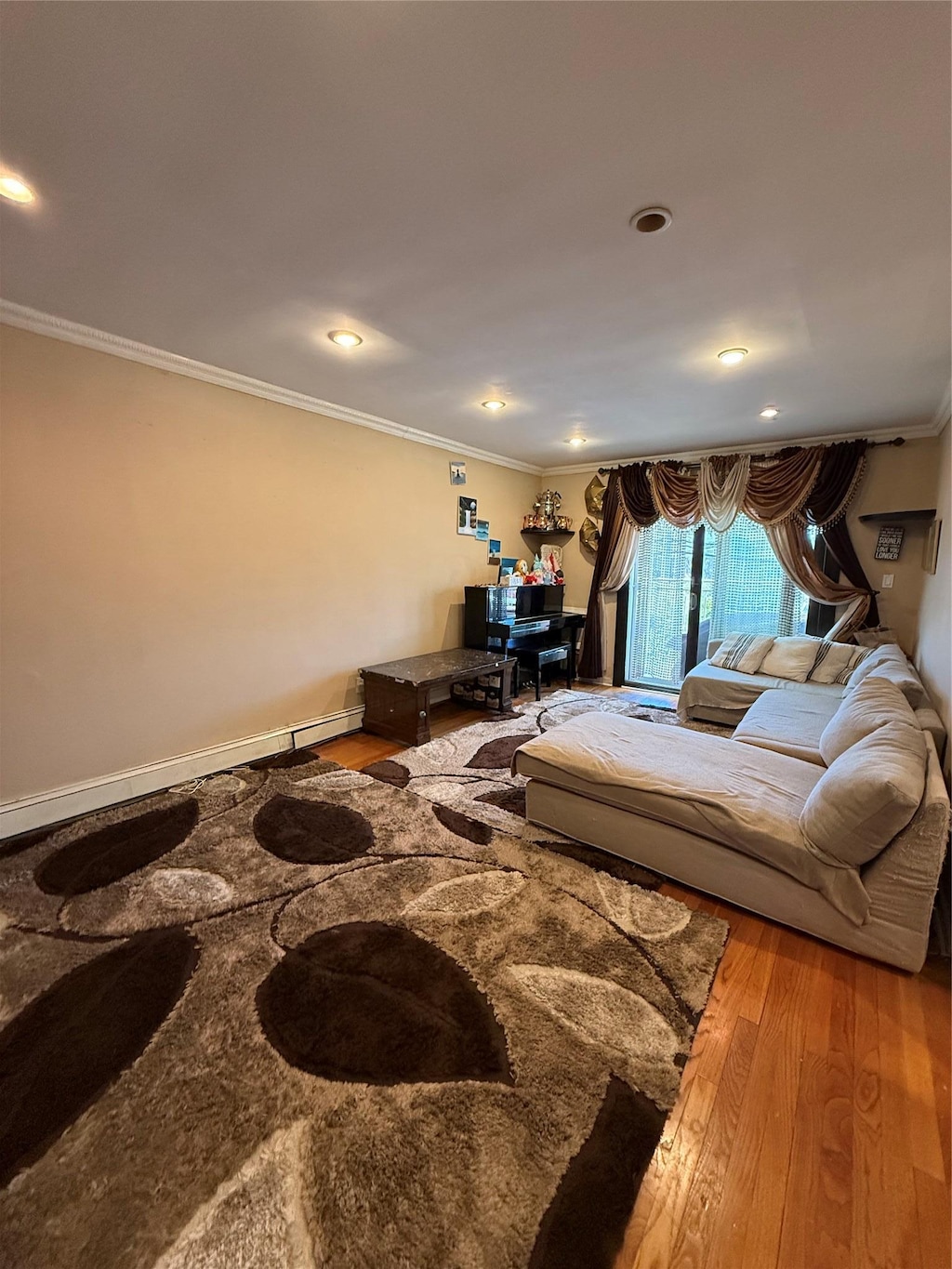 living area with ornamental molding, recessed lighting, and wood finished floors