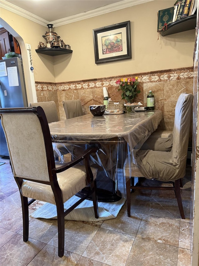 62-23 69th Pl, Middle Village, NY 11379 - dining space featuring crown molding, tile walls, wainscoting, arched walkways, and stone finish floors