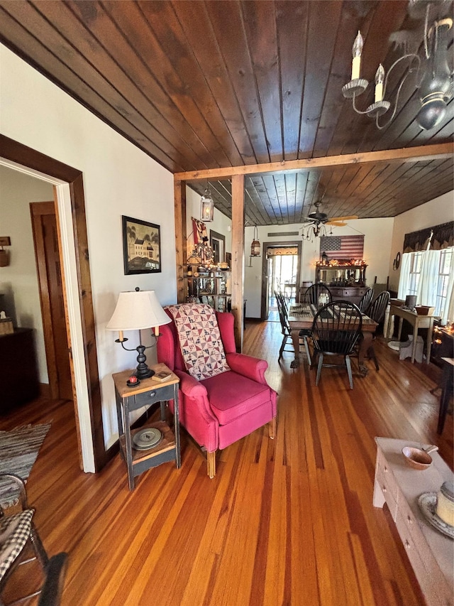 living area featuring a ceiling fan, wood finished floors, and wooden ceiling