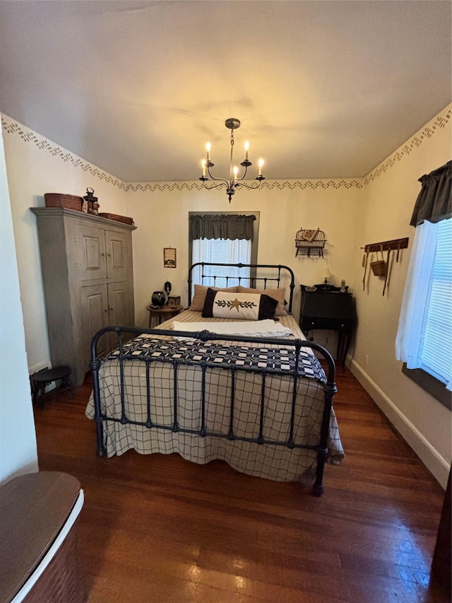 bedroom featuring wood-type flooring, a chandelier, and multiple windows