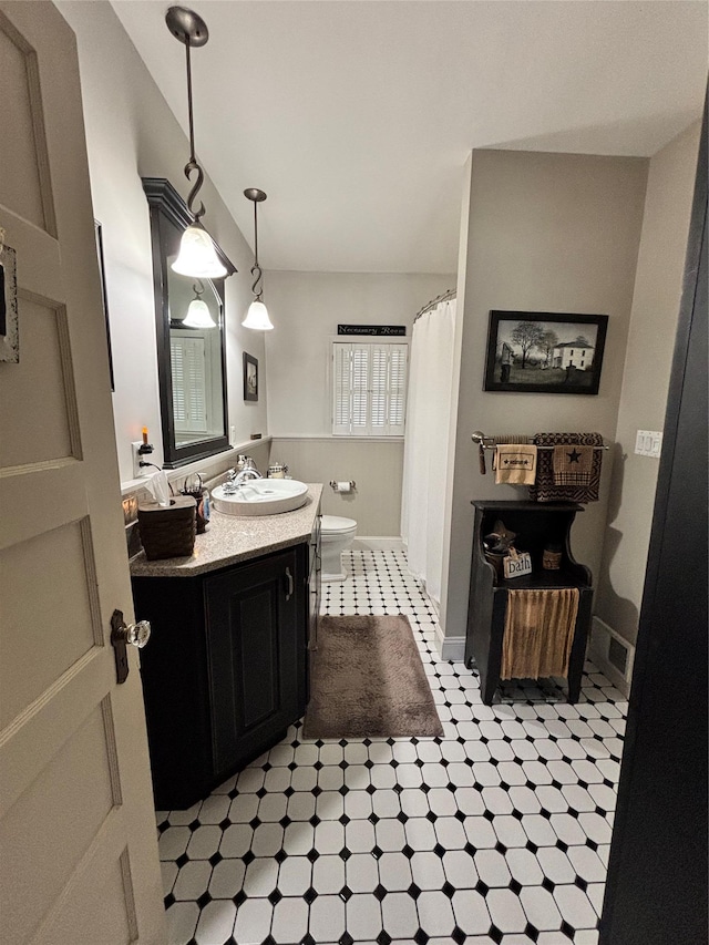 bathroom featuring visible vents, curtained shower, vanity, baseboards, and toilet
