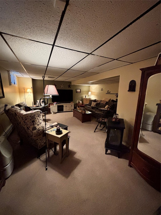 living area featuring carpet and a drop ceiling