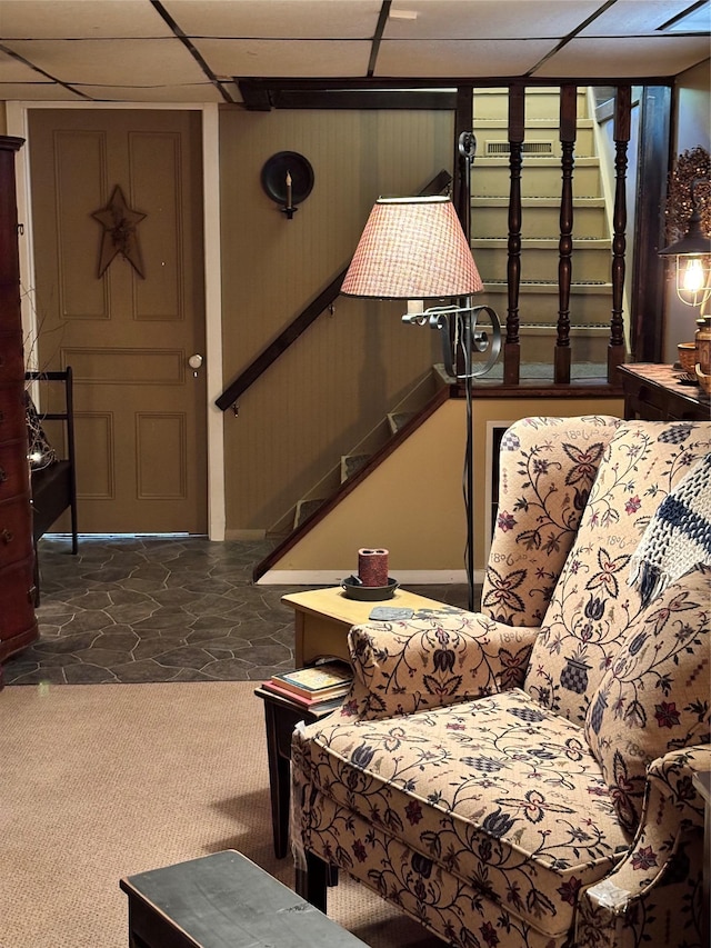 interior space featuring stairs, baseboards, and a drop ceiling