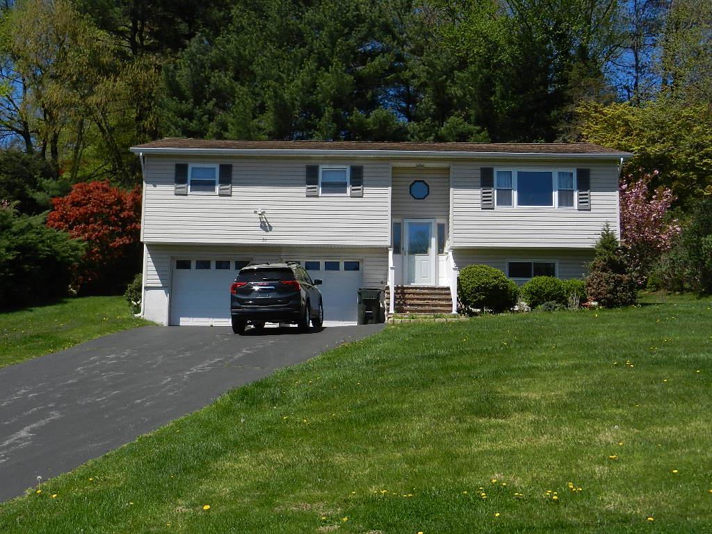 bi-level home with driveway, a front lawn, entry steps, and a garage
